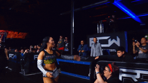 a woman singing into a microphone in a crowd