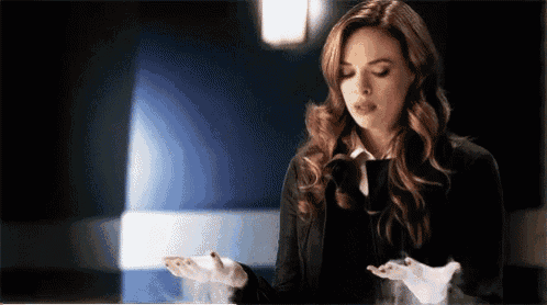 a woman in a black suit is holding something in her hands .