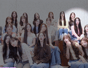 a group of young women are posing for a picture while sitting on a stage .