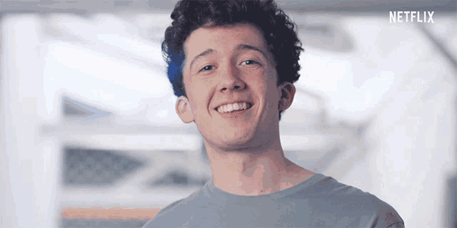 a young man is smiling with a netflix logo in the background