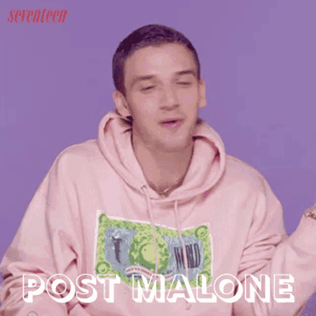 a man wearing a pink hoodie that says post malone on it