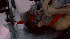 a bottle of ketchup sits on a counter next to a man
