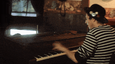 a man in a striped shirt is playing the piano