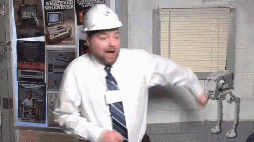 a man in a hard hat is dancing in front of a poster that says whatever wherever