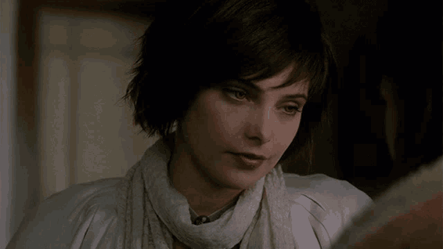 a close up of a woman wearing a scarf and a white jacket