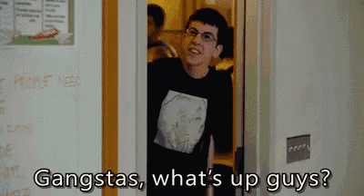 a man in a black shirt is standing in a doorway and says gangstas what 's up guys ?
