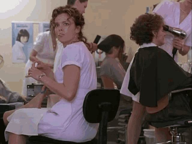 a woman in a white dress is sitting in a chair