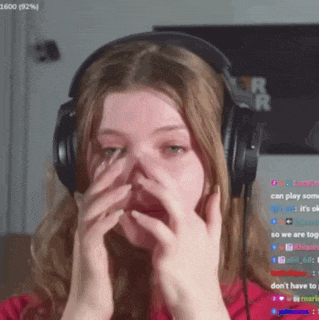 a woman wearing headphones is covering her nose