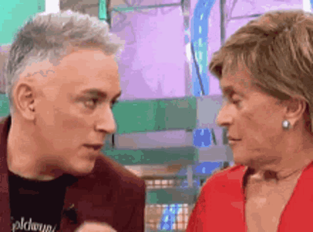 a man and a woman are looking at each other and talking to each other .