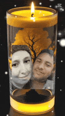 a candle with a picture of a man and a woman inside