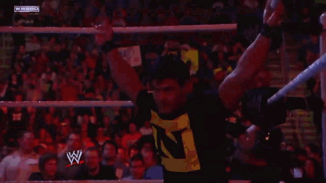 a wrestler in a yellow shirt with the letter n on it