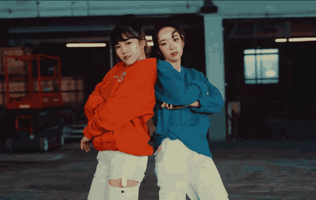 two girls are standing next to each other with one wearing an orange sweatshirt with a letter c on it