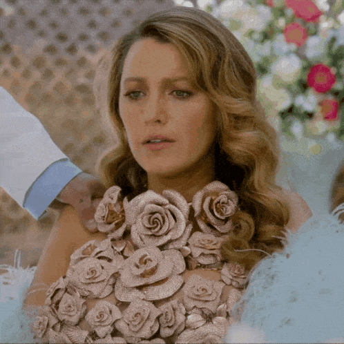 a woman in a dress with roses on it is being held by a man