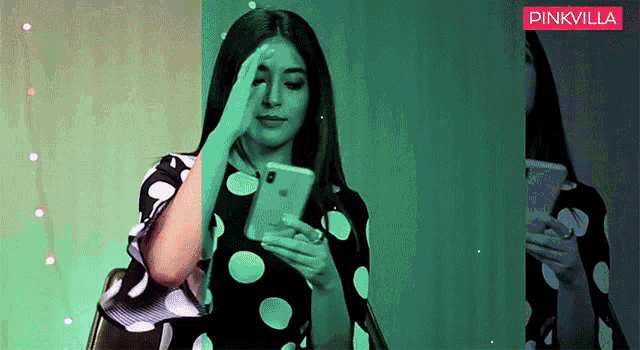 a woman in a black and white polka dot dress is looking at her phone .