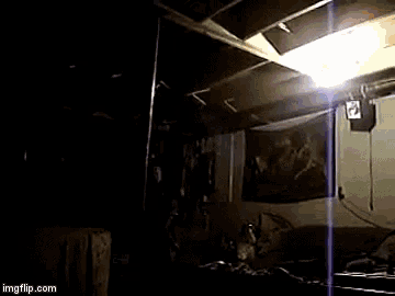 a group of people are standing in a dark room with a light shining through the ceiling ..