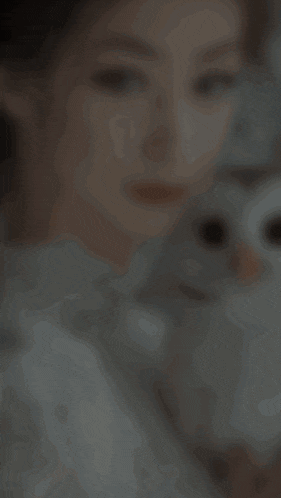 a woman in a white dress holds a white owl