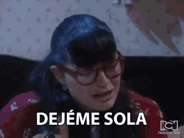a woman with glasses is sitting on a couch and says " dejeme sola "