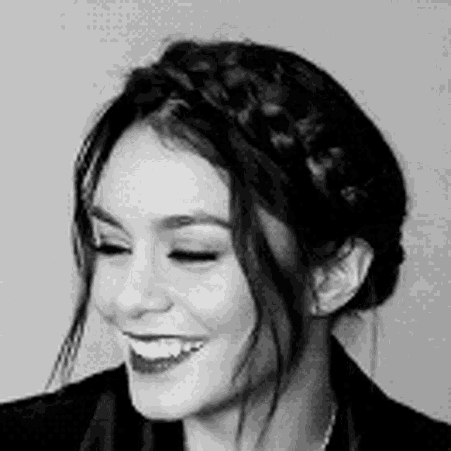 a black and white photo of a woman wearing a braided headband .