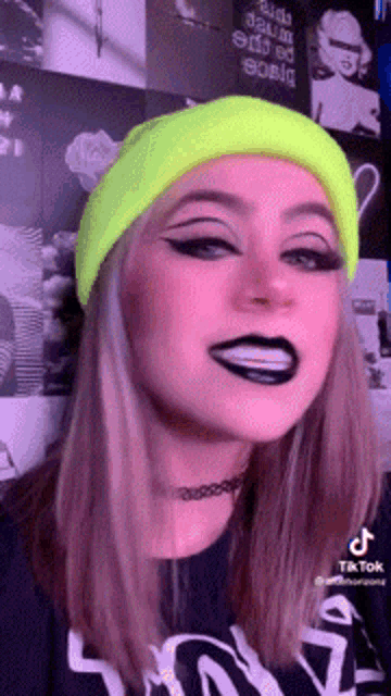 a woman wearing a neon yellow hat and black lipstick .