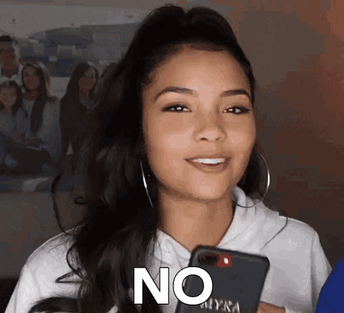 a woman holding a cell phone with the word no written on her face