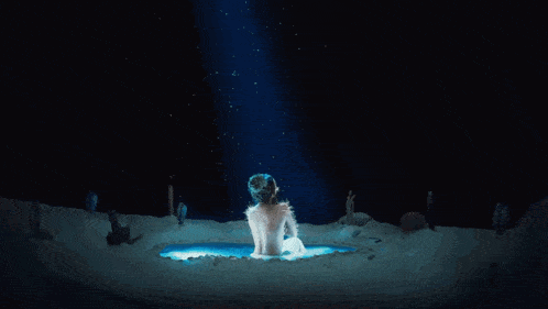 a naked woman with spikes on her back is sitting on a blue surface