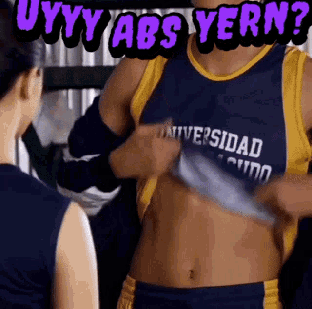 a man in a universidad shirt is showing his abs
