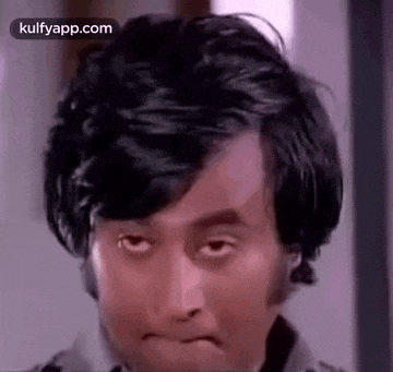a man with long black hair is making a funny face .