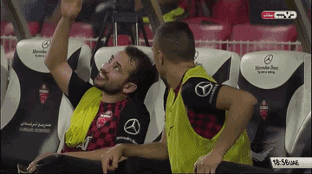 two men are sitting in mercedes benz seats