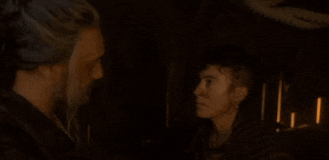 a man and woman are looking at each other in a dark room .