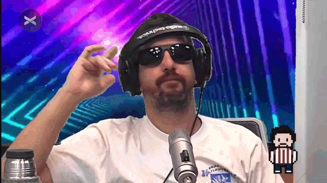 a man wearing headphones and sunglasses is sitting at a microphone