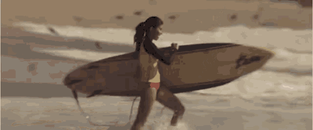 a woman is carrying a surfboard that says ' hawaii ' on it