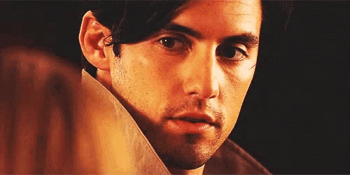 a close up of a man 's face with a woman 's hand behind him .
