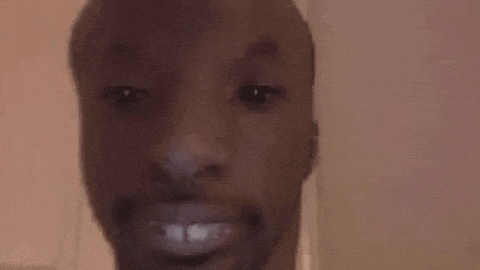 a close up of a man 's face with a beard and a smile .
