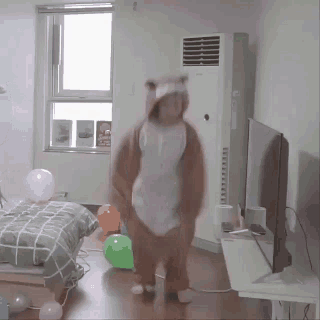 a person in a bear costume is dancing in a bedroom