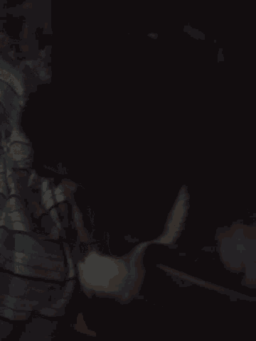 a person in a blue and white striped shirt is laying in the dark