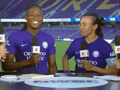 two women wearing purple shirts that say orlando on them