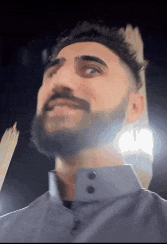 a man with a beard wearing a grey shirt
