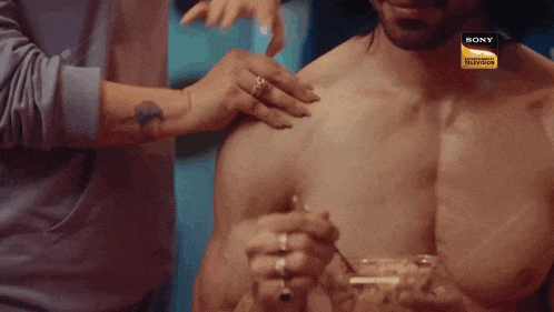a man without a shirt is being touched by a woman with a sony logo on the bottom