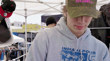 a man wearing a tuesday hat and an indianapolis sweatshirt