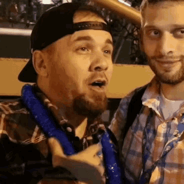 a man with a beard wearing a baseball cap and a plaid shirt