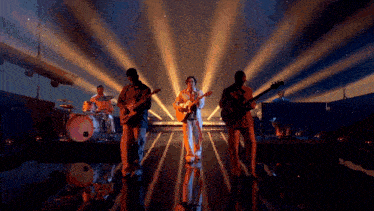 a group of men are playing instruments on stage