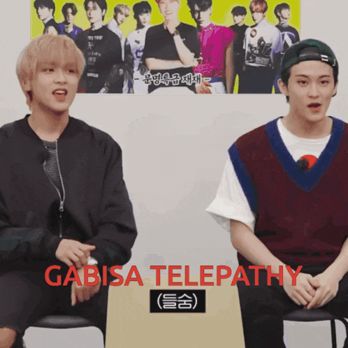 two young men are sitting in front of a yellow poster that says gabisa telepathy
