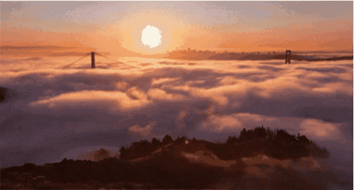 the sun is setting over a bridge surrounded by fog
