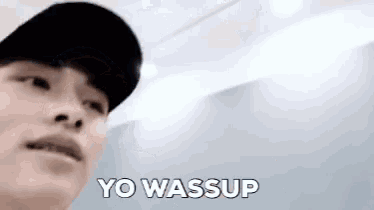 a man wearing a black hat says yo wassup in white letters