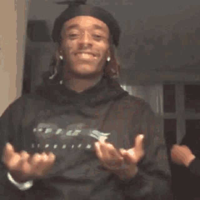 a group of young men are standing next to each other and one of them is wearing a hoodie .
