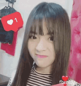 a girl with long hair is smiling with a heart icon in the background