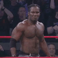 a shirtless man with braids in his hair is smiling .