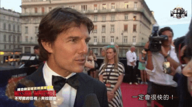 a man in a tuxedo is being interviewed on a red carpet in front of a sign that says missions impossible