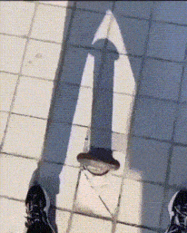 a person 's shadow is cast on a tiled walkway