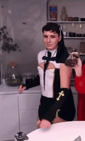 a man in a nun costume holds a candle